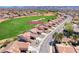 Stunning aerial view of a home on 2734 Grand Forks Rd with lush green golf course, and mountain backdrop at 2734 Grand Forks Rd, Henderson, NV 89052