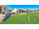 A spacious backyard with lush grass, desert landscaping, and view of the golf course at 2734 Grand Forks Rd, Henderson, NV 89052