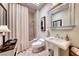 Bright bathroom featuring a vanity sink, toilet, shower, and decorative mirror at 2734 Grand Forks Rd, Henderson, NV 89052