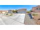 Wide driveway leading to a two-car garage, complemented by desert landscaping at 2734 Grand Forks Rd, Henderson, NV 89052