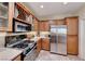 Well-lit kitchen with stainless steel appliances, wooden cabinets, and a tile floor at 2734 Grand Forks Rd, Henderson, NV 89052