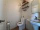 Cozy bathroom with tile flooring, toilet, sink, and overhead shelving at 2804 Marlin Ave, Las Vegas, NV 89101