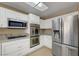 Modern kitchen with white cabinets, granite countertops, stainless steel appliances, and a bright, open layout at 2920 Crown Ridge Dr, Las Vegas, NV 89134