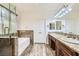 Elegant bathroom with double sinks, granite counters, and tub with marble backsplash at 306 Saint Augustine Ln, Henderson, NV 89014