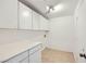 Bright laundry room features ample cabinet space, tile floors, and white countertops at 306 Saint Augustine Ln, Henderson, NV 89014