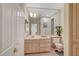 Bathroom with white cabinets, a large mirror, neutral tile, and a separated toilet at 364 Wild Plum Ln, Las Vegas, NV 89107