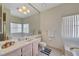 Bathroom features an extra-large mirror, marble vanity and a soaking tub with a window at 364 Wild Plum Ln, Las Vegas, NV 89107
