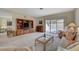 Spacious living room with plush carpet, sliding glass doors, and a classic entertainment center at 364 Wild Plum Ln, Las Vegas, NV 89107