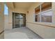 A covered patio with stucco walls, sliding glass doors, and a window offers a cozy outdoor retreat at 364 Wild Plum Ln, Las Vegas, NV 89107
