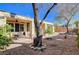 Backyard featuring desert landscaping, covered patio, and mature trees at 3663 Coventry Gardens Dr, Las Vegas, NV 89135
