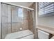Bathroom featuring a tub with glass door and light neutral tiling at 3663 Coventry Gardens Dr, Las Vegas, NV 89135