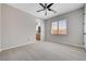 Well-lit bedroom with plush carpet, ceiling fan, and a glimpse of the adjacent bathroom at 3663 Coventry Gardens Dr, Las Vegas, NV 89135