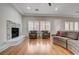 Bright living room featuring a modern fireplace, hardwood floors, comfortable seating, and natural light through large windows at 3663 Coventry Gardens Dr, Las Vegas, NV 89135