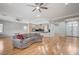 Open-concept living space featuring wood floors, ceiling fans, and a view into the kitchen area at 3663 Coventry Gardens Dr, Las Vegas, NV 89135