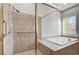 Bathroom with tiled walk-in shower, soaking tub, and window providing natural light at 3663 Coventry Gardens Dr, Las Vegas, NV 89135