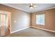 Neutral bedroom features a ceiling fan, window with blinds, and doorway leading to a hallway at 3920 Legend Hills St # 202, Las Vegas, NV 89129