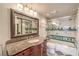 Traditional bathroom with a granite vanity, large mirror, and shower-over-tub with green accent tile at 4043 Chalfont Ct, Las Vegas, NV 89121