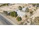 Expansive property featuring lush trees, rock pathway, and fenced perimeter on a desert landscape at 4838 N Tioga Way, Las Vegas, NV 89149