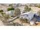 Wide aerial shot of a property with two houses, trees, and a large yard in a desert landscape at 4838 N Tioga Way, Las Vegas, NV 89149