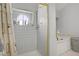 Clean, tiled shower stall with a round window for natural light and shelving for products at 4838 N Tioga Way, Las Vegas, NV 89149