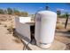Close exterior shot of the water tank and surrounding dry landscape at 4838 N Tioga Way, Las Vegas, NV 89149