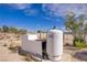 Exterior shot of the white water tank and concrete pad near shrubbery and desert landscape at 4838 N Tioga Way, Las Vegas, NV 89149