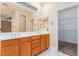 Bathroom featuring double sinks, lots of counter space, and a walk-in closet with custom shelving at 5046 Great Abaco St, North Las Vegas, NV 89031