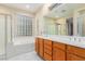 Bright bathroom featuring double sinks, a large bathtub, and decorative window for natural light at 5046 Great Abaco St, North Las Vegas, NV 89031