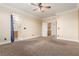 Spacious bedroom featuring a ceiling fan, carpet and entrances to two bathrooms at 5046 Great Abaco St, North Las Vegas, NV 89031