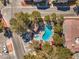Aerial view of a neighborhood pool featuring lush landscaping and a nearby picnic area with an umbrella at 5250 S Rainbow Blvd # 2046, Las Vegas, NV 89118