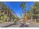 Gated community entrance with palm trees and manicured landscaping at 5250 S Rainbow Blvd # 2046, Las Vegas, NV 89118