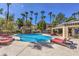 Community pool with sun loungers, palm trees, and cabana area at 5250 S Rainbow Blvd # 2046, Las Vegas, NV 89118