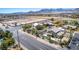 An aerial view of a residential area with palm trees, pools, and mountain views at 5640 Coe Estates Ct, Las Vegas, NV 89149