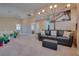 Comfortable bonus room with a dark leather sofa, contemporary light fixture, and palm tree art at 5640 Coe Estates Ct, Las Vegas, NV 89149