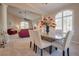 A dining room with a granite table, adjacent to living room with high ceilings and natural light at 5640 Coe Estates Ct, Las Vegas, NV 89149