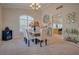 A dining room with an elegant chandelier and large windows, adjacent to an open living space at 5640 Coe Estates Ct, Las Vegas, NV 89149