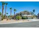 Inviting two-story home with desert landscaping, palm trees, and a three-car garage at 5640 Coe Estates Ct, Las Vegas, NV 89149