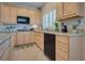 A bright kitchen with wooden cabinets, granite countertops, and a built-in dishwasher offers a functional design at 5640 Coe Estates Ct, Las Vegas, NV 89149