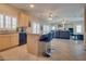 A kitchen with bar seating, granite countertops, and stainless steel appliances, leading to an open living room at 5640 Coe Estates Ct, Las Vegas, NV 89149