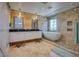 Bathroom with wood paneling, double sinks, soaking tub in the shower, and a modern aesthetic at 5640 Coe Estates Ct, Las Vegas, NV 89149