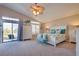 Bedroom with a large bed, vaulted ceilings, bench, and sliding glass door to the backyard at 5640 Coe Estates Ct, Las Vegas, NV 89149