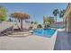 Inviting pool with a thatched umbrella and lounge chair, perfect for relaxing by the water at 5640 Coe Estates Ct, Las Vegas, NV 89149