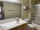 Standard bathroom with large mirror, basic vanity, and a shower-tub combination with sliding doors at 5710 E Tropicana Ave # 2033, Las Vegas, NV 89122