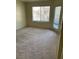 Living room featuring new carpet, a window, and a door leading to a balcony at 5710 E Tropicana Ave # 2033, Las Vegas, NV 89122