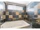 Bathroom featuring a bath tub, patterned stone tile and shower head at 6213 Burgundy Way, Las Vegas, NV 89107