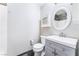 A modern bathroom with gray vanity, new fixtures, slate tile floor, cabinet, and white painted walls at 6213 Burgundy Way, Las Vegas, NV 89107