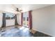 Inviting bedroom with slate floors, neutral walls, a ceiling fan, and bright double doors to outside at 6213 Burgundy Way, Las Vegas, NV 89107