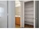 Hallway view of bathroom with wood vanity and organized, bright, walk-in closet at 6234 Pangea Ave, Las Vegas, NV 89139
