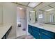Bathroom features vanity with blue cabinets and double mirror at 6357 Vicuna Dr, Las Vegas, NV 89146