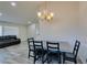 Dining area with chandelier, wood-look floors, and views into the living room at 6357 Vicuna Dr, Las Vegas, NV 89146